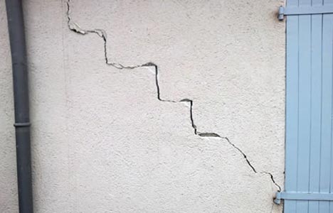 Fissure sur la façade du Roy, visible sur un mur en béton.
