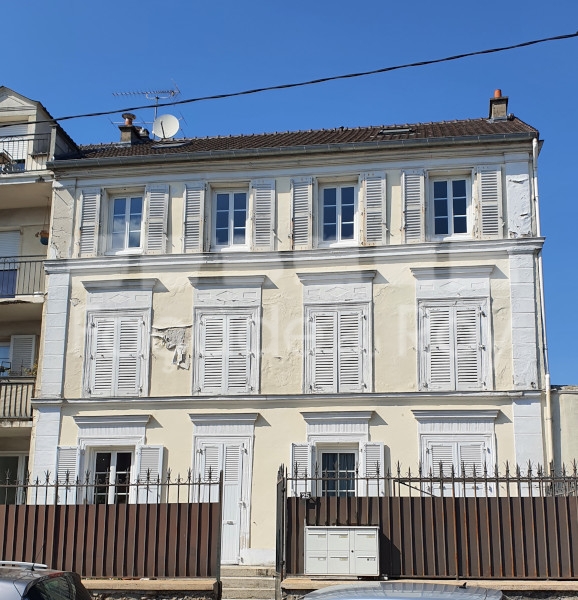 Façade du Roy avec volets et fenêtres blanches, bâtiment à deux étages.