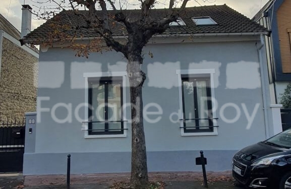 Façade du Roy avec fenêtres noires et toit en tuiles, arbre devant.
