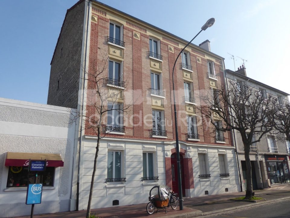 Façade du Roy avec balcons et briques sur rue animée.