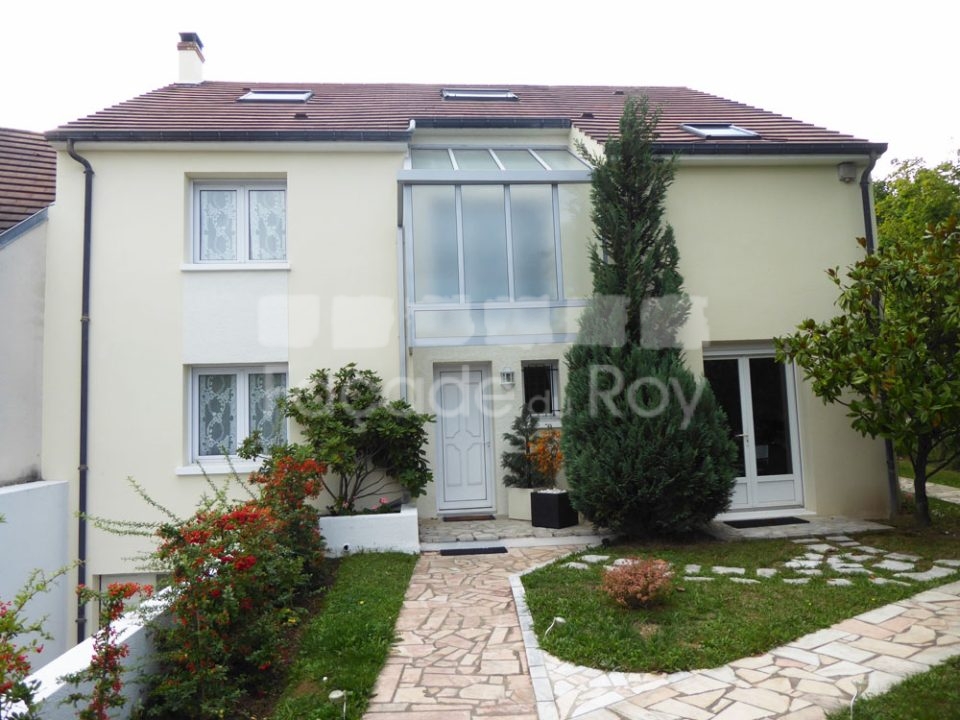 Façade du Roy d'une maison moderne avec jardin et allée en pierre.