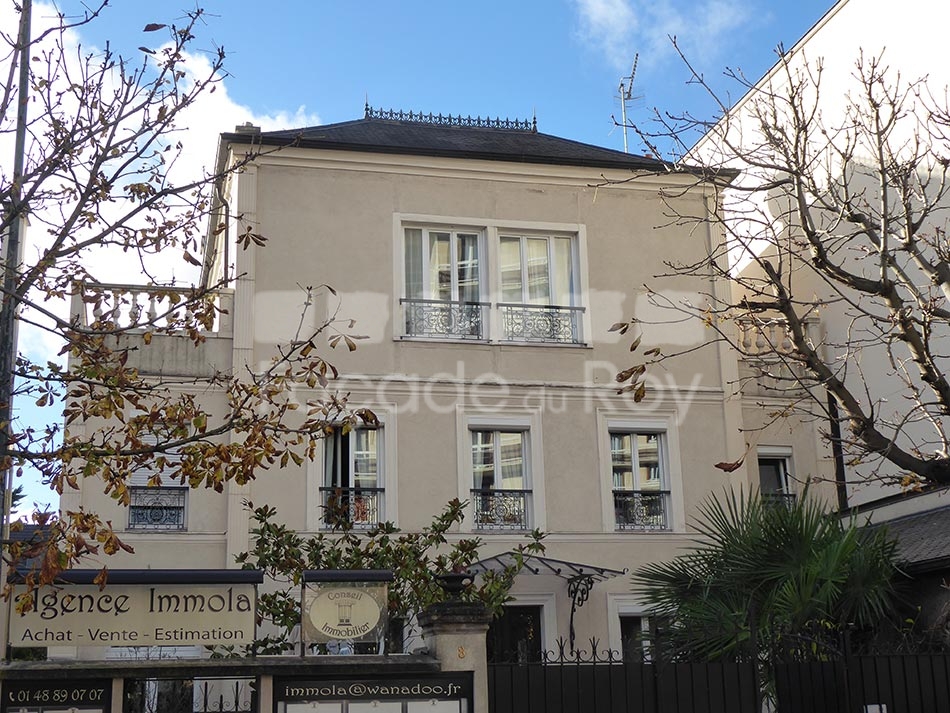 Façade du Roy avec balcons en fer forgé et détails architecturaux.
