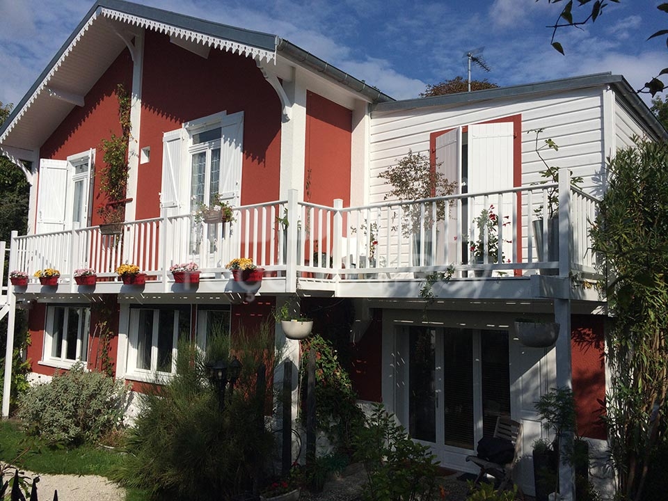 Façade du Roy avec balustrade et pots de fleurs colorés.